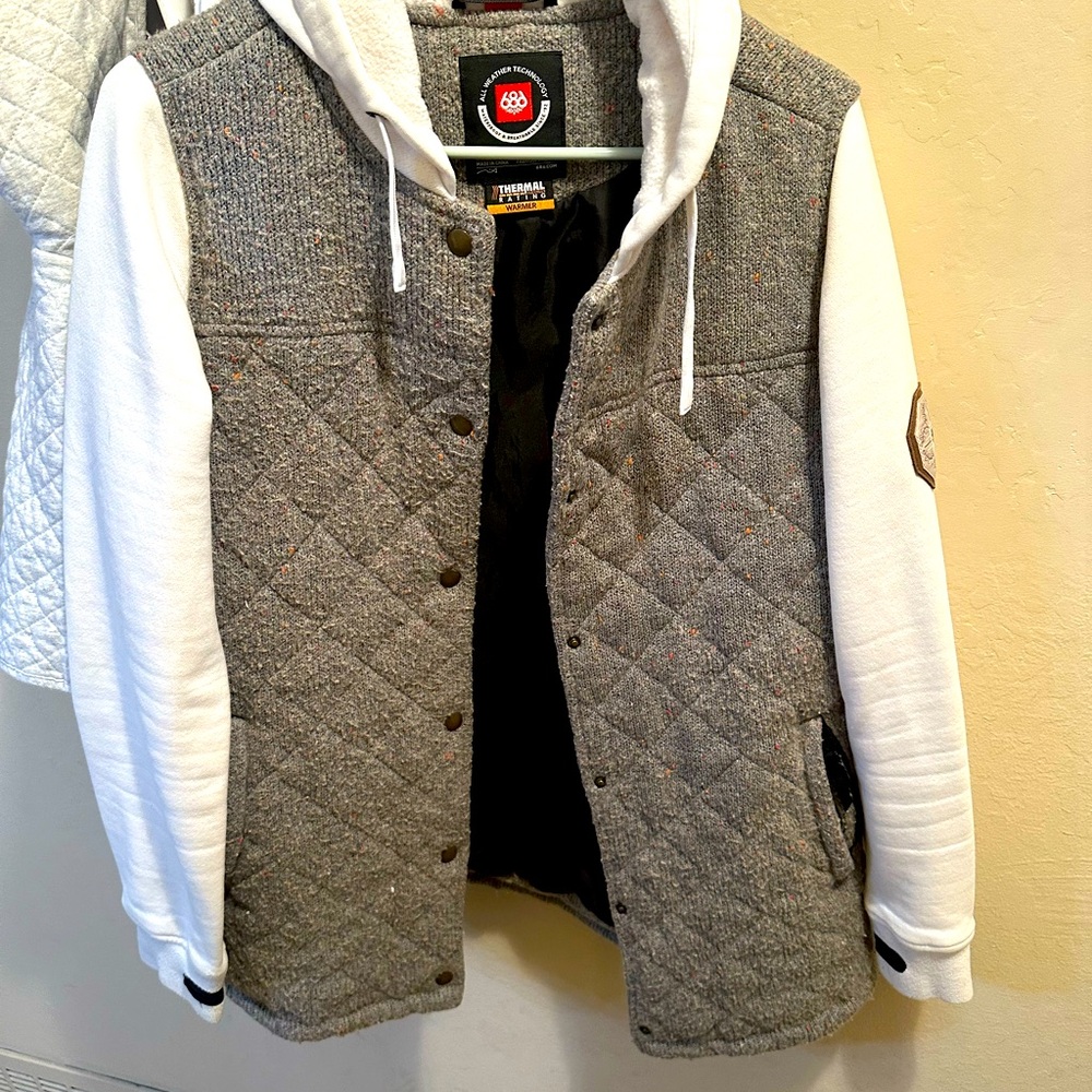 Winter jacket gray wool center with white sleeves and hoodie with buttons.